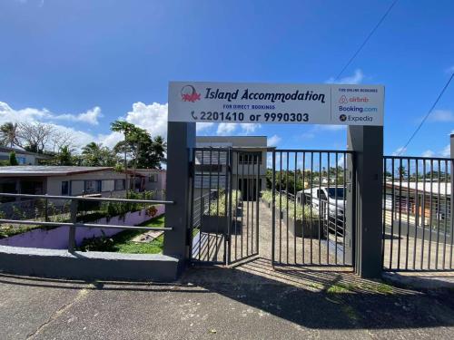 a gate with a sign in front of a building at Island Travelers Accommodation in Suva