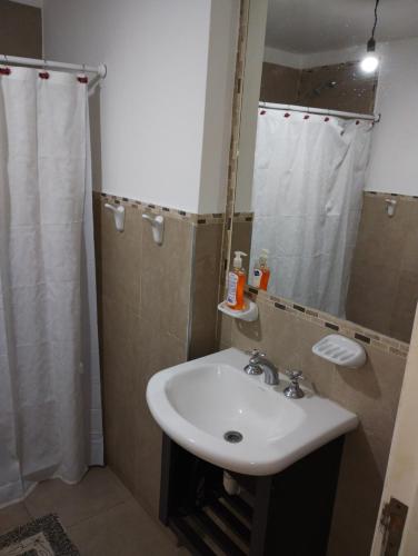 a bathroom with a sink and a shower with a mirror at Departamento Centro de Santiago del Estero in Santiago del Estero