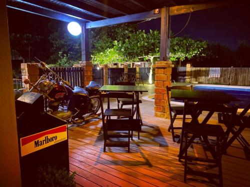 un patio con una mesa y sillas y una motocicleta aparcada en Pousada Morrison, en Praia do Rosa