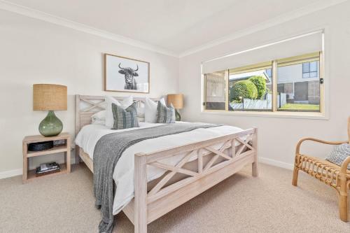 a bedroom with a large bed and a window at On Cyrus at Hyams Beach in Hyams Beach