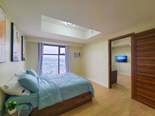 a bedroom with a bed and a large window at 1 Bedroom Suite-City View-Horizons in Cebu City
