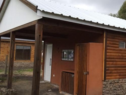 uma cabana com um telhado branco e uma porta em Villa Arcadia em Sierra de la Ventana