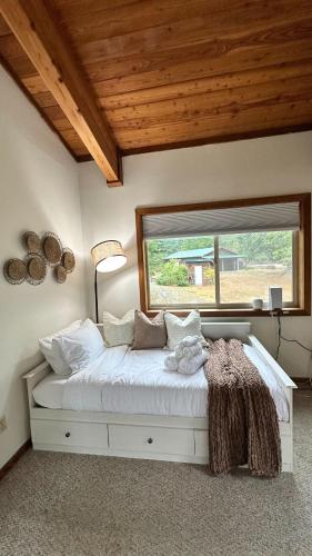a bedroom with a white bed with a large window at New Sauk River Retreat Concrete Wa in Concrete