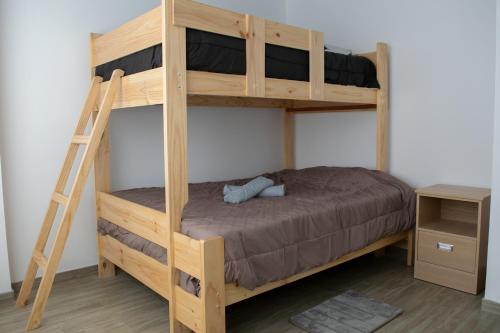 Ce lit superposé en bois se trouve dans un dortoir avec une échelle. dans l'établissement Morada, à Tacna