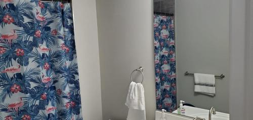 a bathroom with a shower curtain and a sink and a mirror at Welcome to our newly built house in Glen Burnie