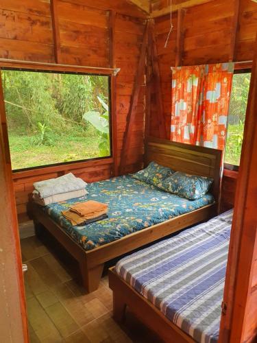 a bedroom with two beds in a log cabin at Into the Greens in Madre de Dios