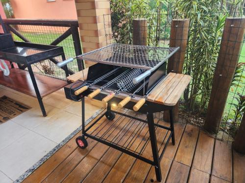 a barbecue grill on a cart on a deck at Apartamento na Praia do Saco - Condomínio Villa das Águas in Estância