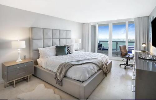 a white bedroom with a large bed and a desk at Good Morning Beautiful! Direct Water Views in Miami