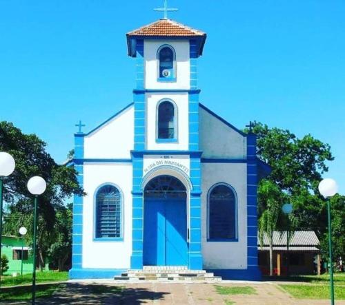 a blue and white church with a clock tower at Cabana praia dos passarinhos in Viamão