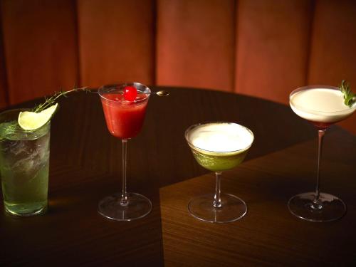 three cocktails are sitting on a table at Dusit Thani Kyoto in Kyoto