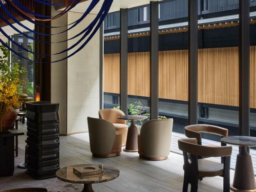 a lobby with tables and chairs and large windows at Dusit Thani Kyoto in Kyoto
