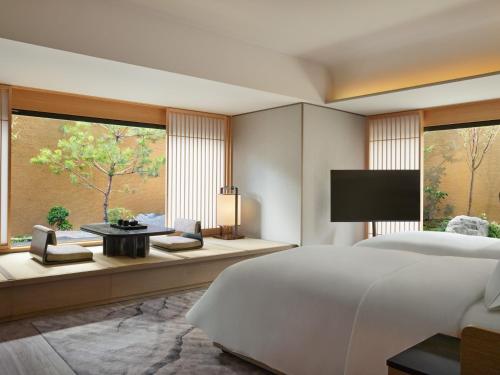 a bedroom with a large bed and a large window at Dusit Thani Kyoto in Kyoto