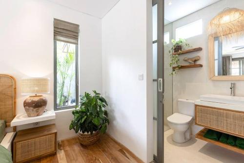 uma casa de banho com um lavatório, um WC e uma janela. em Villa Asri Canggu 3br, Poolside sofa & bar area em Canggu
