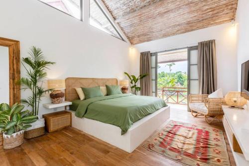 um quarto com uma cama com uma colcha verde em Villa Asri Canggu 3br, Poolside sofa & bar area em Canggu