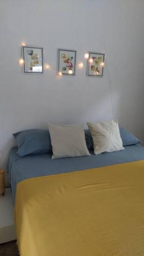 1 dormitorio con 1 cama con 4 cuadros en la pared en Quédate Aquí en Las Galeras