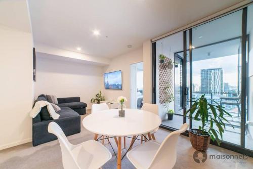 Una sala de estar con una mesa y sillas y un sofá. en Mod Brisbane Apt near Southbank W Pool & Parking, en Brisbane