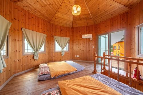 濟州的住宿－Love Pension，木制客房内的一间卧室配有两张床