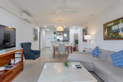 Caribbean Oasis on Sunset Beach في Maho Reef: غرفة معيشة مع أريكة وطاولة