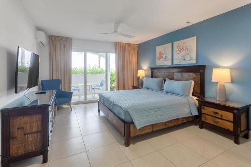 ein Schlafzimmer mit einem Bett und einem Schreibtisch mit einem Schreibtisch in der Unterkunft Caribbean Oasis on Sunset Beach in Maho Reef