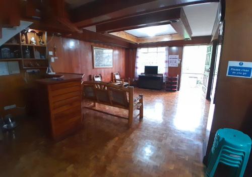 uma sala de estar com paredes de madeira e piso de madeira em Amara Transient House em Baguio