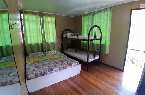 two bunk beds in a room with green curtains at Amara Transient House - Homestay in Baguio