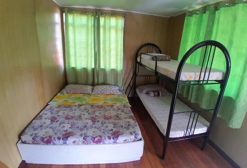 two bunk beds in a small room with green curtains at Amara Transient House - Homestay in Baguio