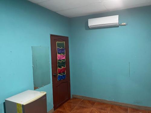 a room with a blue wall with a window and a door at Casa Hogar Martita in Puerto Baquerizo Moreno