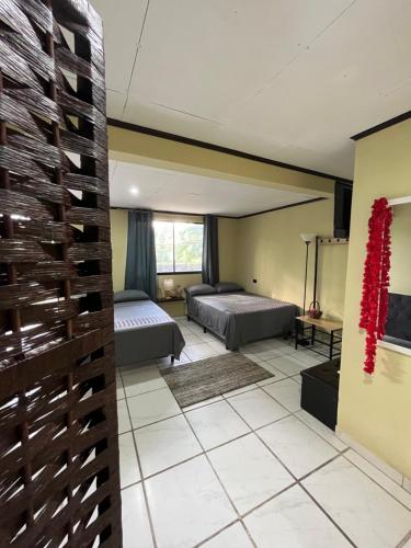a living room with two beds and a room with two beds at Hotel Azul Coral in Cahuita