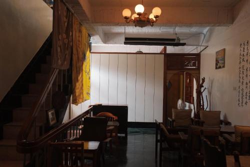 a room with a staircase and tables and chairs at MUSEaUM 沐洋人 in Hengchun