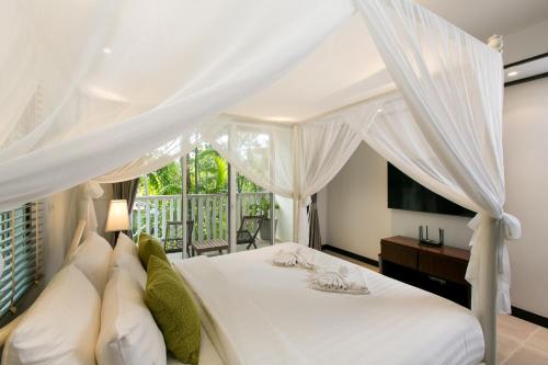 1 dormitorio con cama blanca y ventana en Katamanda Villa Mila A1, en Kata Beach