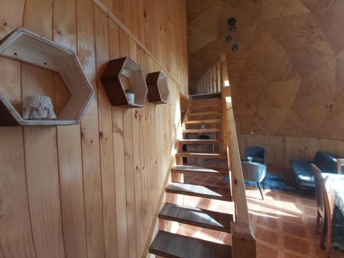 a staircase in a room with a wooden wall at Domos Maran Lican Ray in Licán Ray