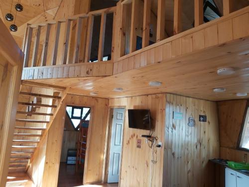 a wooden cabin with a staircase in a room at Domos Maran Lican Ray in Licán Ray