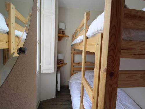 Cette chambre comprend 2 lits superposés et une porte. dans l'établissement Luchon - 2 Pièces Cabine pour 6 Pers. avec Parking et Animaux admis - FR-1-313-226, à Luchon