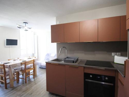 eine Küche mit einem Waschbecken und einem Tisch mit einem Esszimmer in der Unterkunft Appartement Bagnères-de-Luchon, 2 pièces, 6 personnes - FR-1-313-226 in Luchon