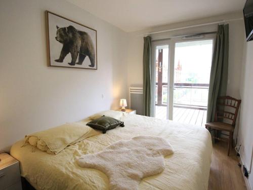 - une chambre dotée d'un lit avec une photo d'ours sur le mur dans l'établissement Appartement Cozy 3P avec Balcon Sud, Garage et Proche Golf - Montauban-de-Luchon - FR-1-313-227, à Montauban-de-Luchon