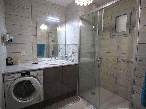 une salle de bain avec une machine à laver et un lavabo dans l'établissement Appartement Cozy 3P avec Balcon Sud, Garage et Proche Golf - Montauban-de-Luchon - FR-1-313-227, à Montauban-de-Luchon
