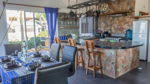cocina con mesas, sillas y encimera en Sunset Beachside Villa, en Puerto Escondido