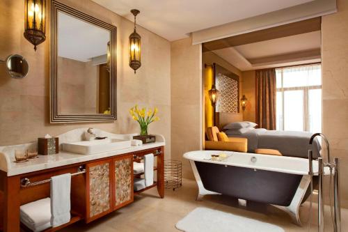 La salle de bains est pourvue d'un lavabo, d'une baignoire et d'un lit. dans l'établissement Sheraton Qingyuan Lion Lake Resort, à Qingyuan