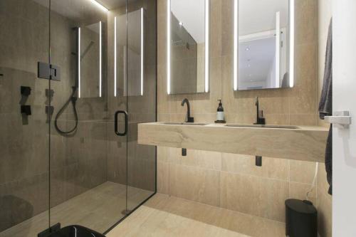 a bathroom with two sinks and a shower at Entertainers penthouse with 5 bedrooms pool & spa in Auckland