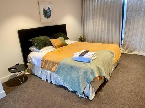 Un dormitorio con una cama con un teléfono. en Entertainers penthouse with 5 bedrooms pool & spa en Auckland