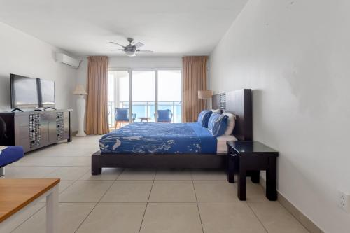 sypialnia z łóżkiem i telewizorem w pokoju w obiekcie Sand Bar Cove - Beach Bar Studio next to The Morgan Resort w mieście Maho Reef