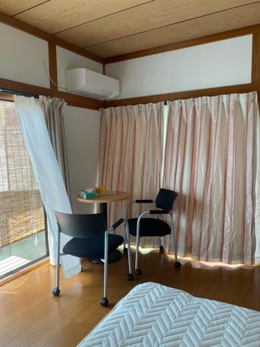 1 dormitorio con mesa, sillas y 1 cama en 民泊　筑紫野, en Chikushino
