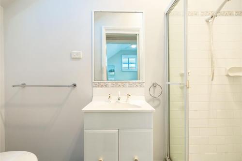 Un baño blanco con lavabo y ducha. en 43 Squire Street Fingal Bay, en Fingal Bay