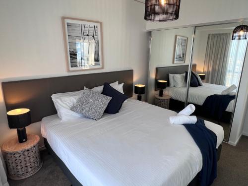 a hotel room with two beds and a mirror at Incredible ocean views 3 Bed 18th floor in Gold Coast