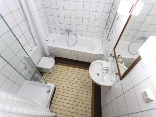 a bathroom with a sink and a tub and a toilet at Basmanka Convent Hotel in Moscow