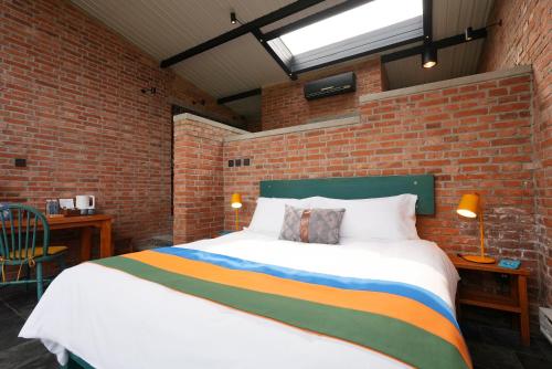 a bedroom with a large bed in a brick wall at Brickyard Retreat at Mutianyu Great Wall Adjoin to Mutianyu Great Wall - Room with the View of Great Wall - Chinese massage experience - Vehicle Shuttle Service - International Catering - SPA& Nail Beauty Facilities in Huairou