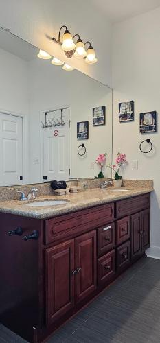 a bathroom with two sinks and a large mirror at PRIVATE BEACH -- AWAY FROM THE CROWDS - Ocean Views -Short drive to MOODY GARDENS, SCHLITTER BAHN, PLEASURE PIER in Galveston