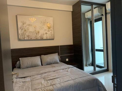 a bedroom with a bed and a large window at Batam Two Bedrooms Apartment - One Residence 25AJ in Batam Center