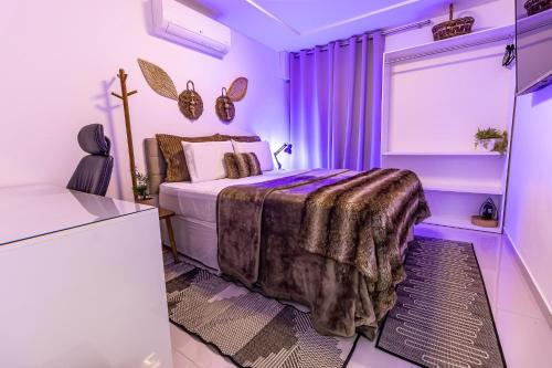 um quarto roxo com uma cama e uma janela em Apartamentos com internet rápida em Maceió