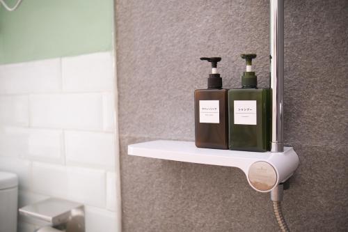 two bottles of soap sitting on a shelf in a bathroom at Ashamaya Belitung (Dome Glamping Site) in Pasarbaru